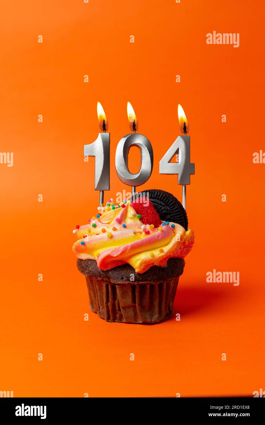 birthday cake with number 104 cupcake on orange background with