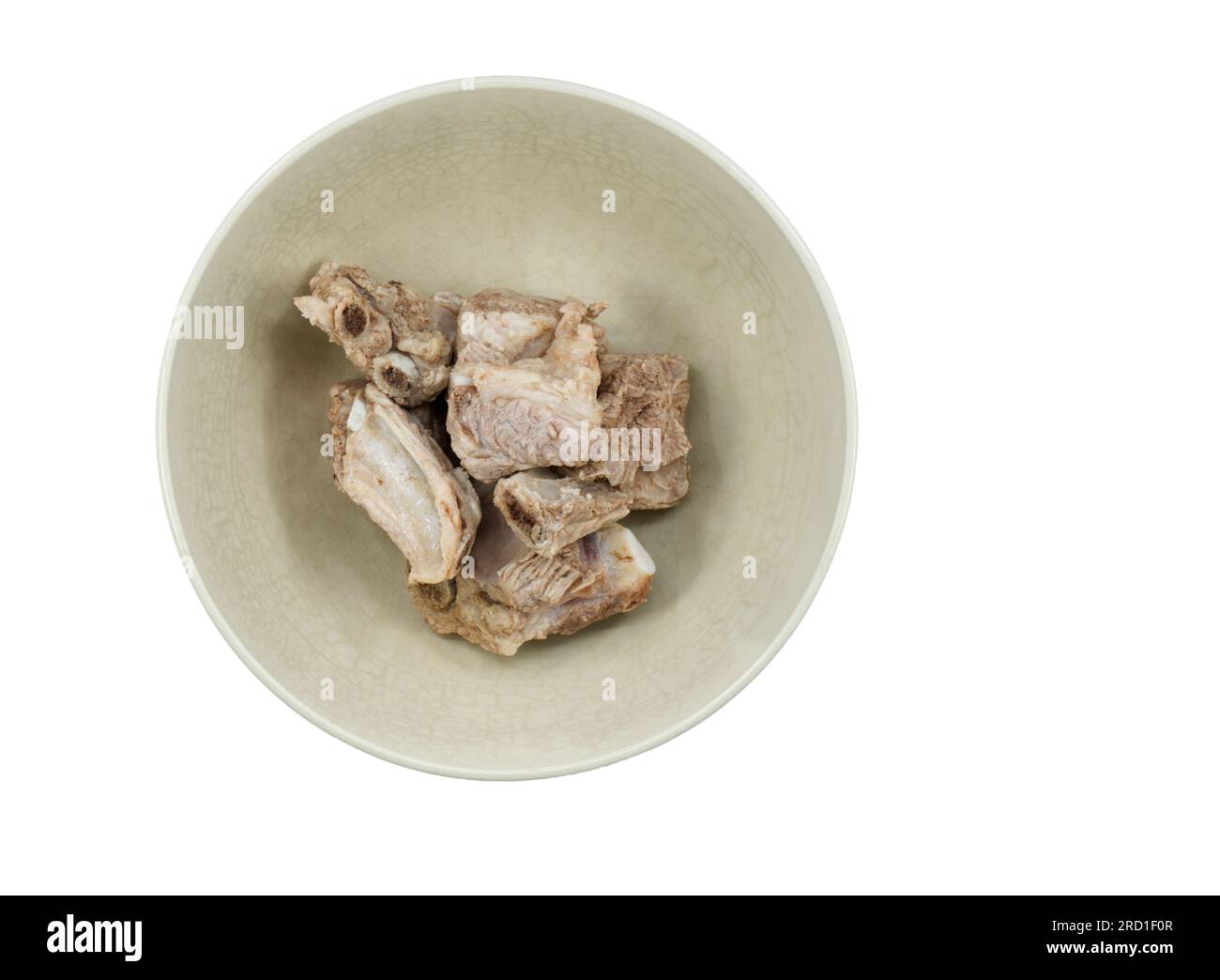 Isolated half-done spare ribs or pig bones in an old bowl on white background, top view image of spare ribs in a bowl, preparing spare ribs for cookin Stock Photo