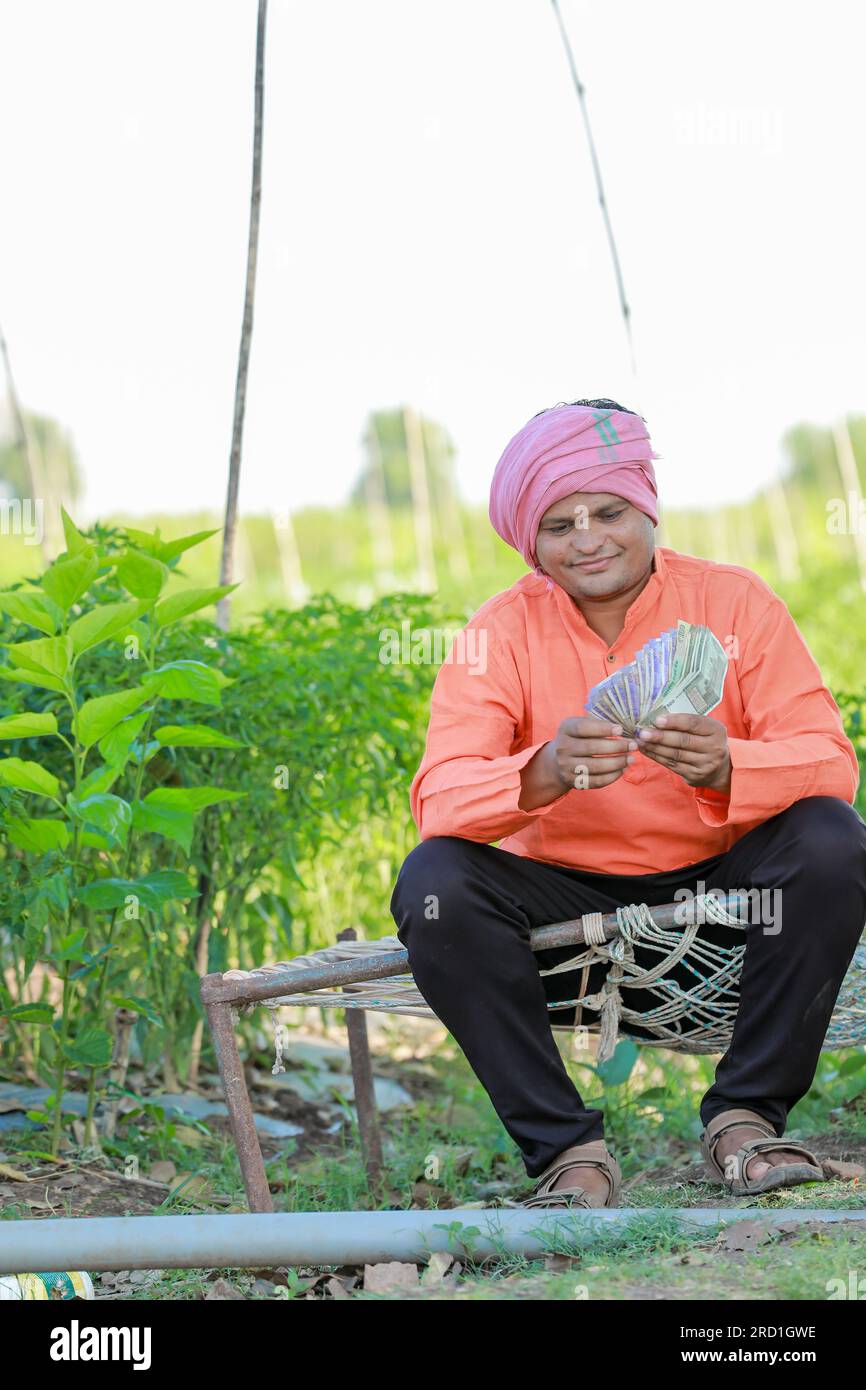 Happy Indian farmer, farmer holding indian rupees in hands, smart ...
