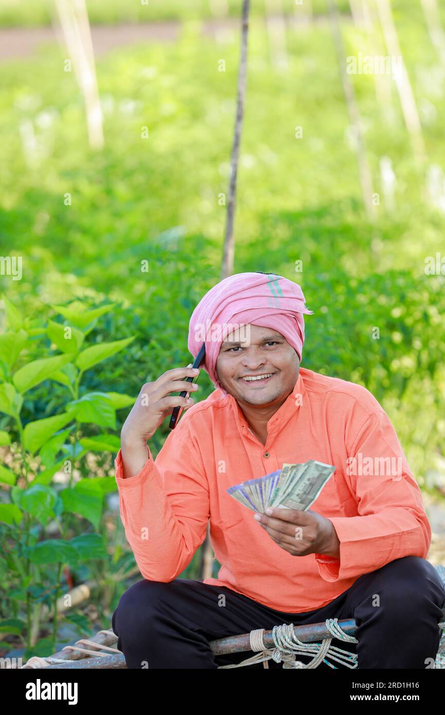 Happy Indian farmer, farmer holding indian rupees in hands, smart