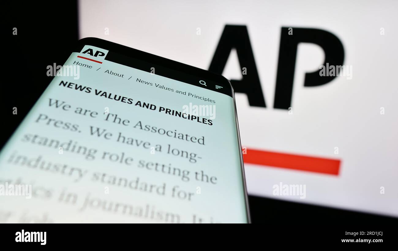 Mobile phone with website of US news agency Associated Press (AP) on screen in front of logo. Focus on top-left of phone display. Stock Photo
