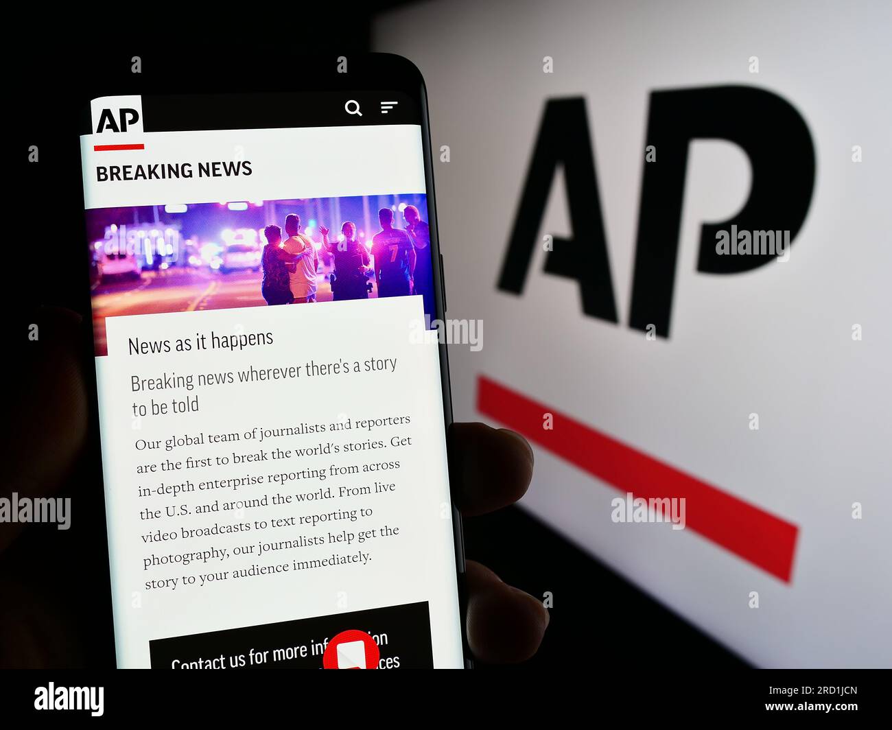 Person holding smartphone with website of US news agency Associated Press (AP) on screen in front of logo. Focus on center of phone display. Stock Photo