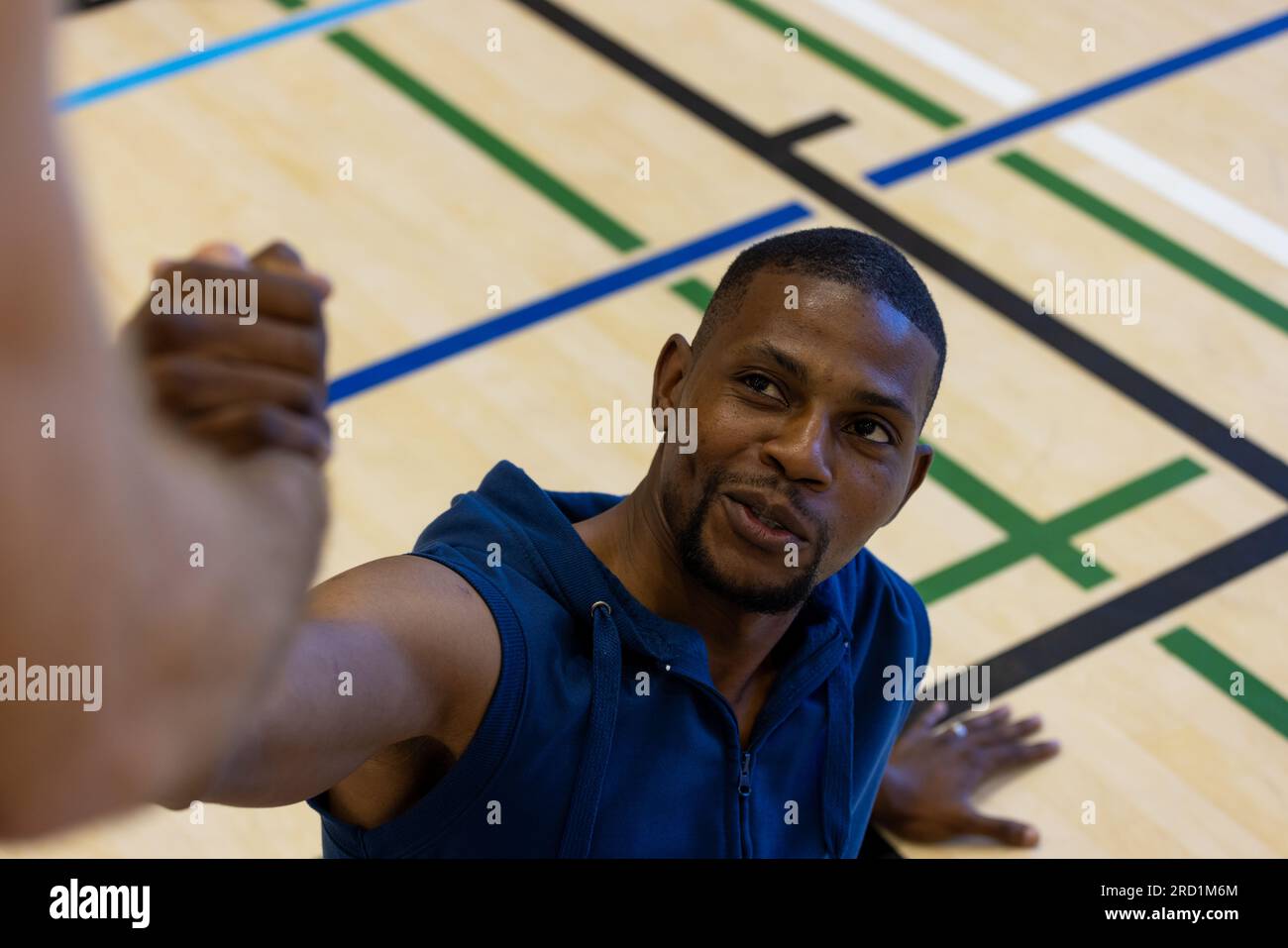 Diverse male basketball players helping to get up at gym Stock Photo Alamy