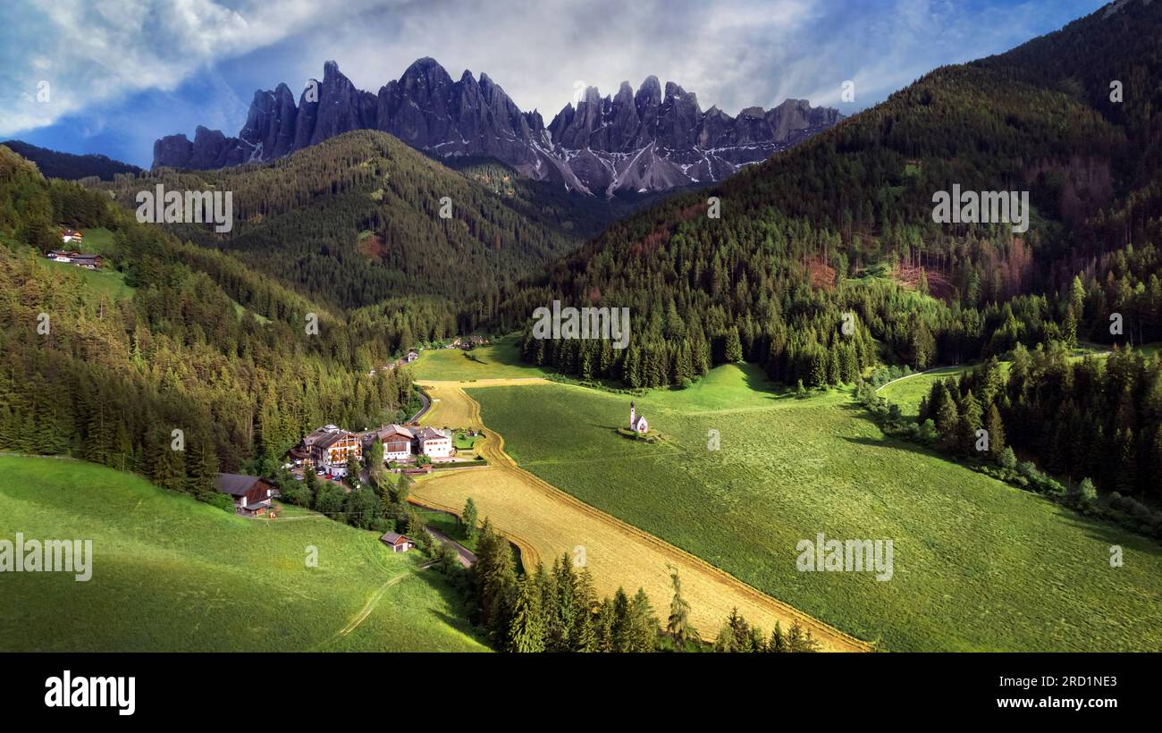 Stunning Alpine scenery of breathtaking Dolomites rocks mountains in Italian Alps, South Tyrol, Italy. Aerial view of Val di Funes and village Maddale Stock Photo