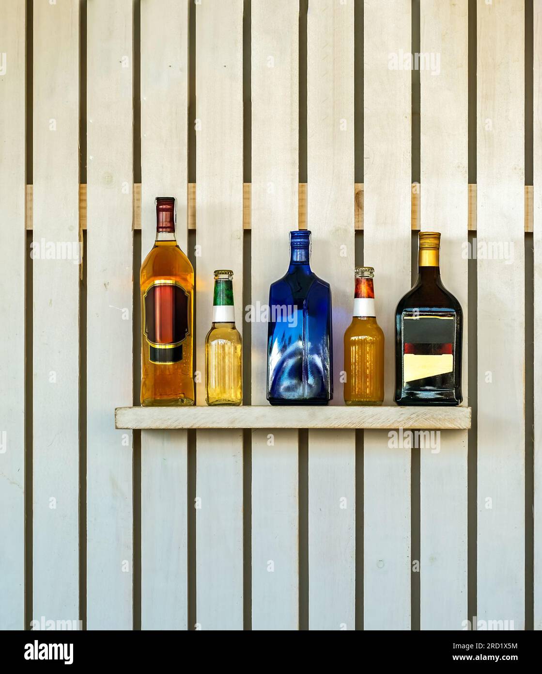 Bottles of alcoholic beverages on a wooden shelf Stock Photo - Alamy