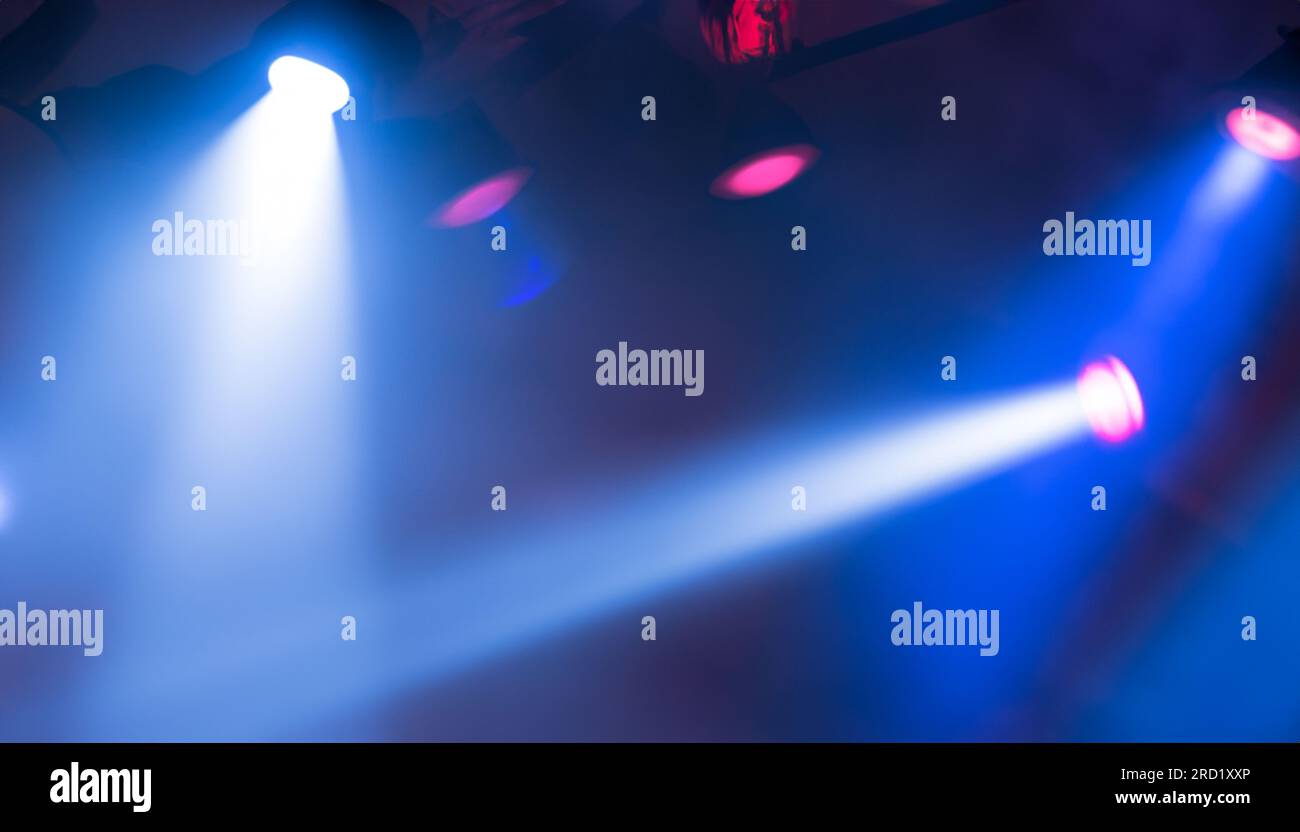 projectors light beam through smoke on stage Stock Photo - Alamy