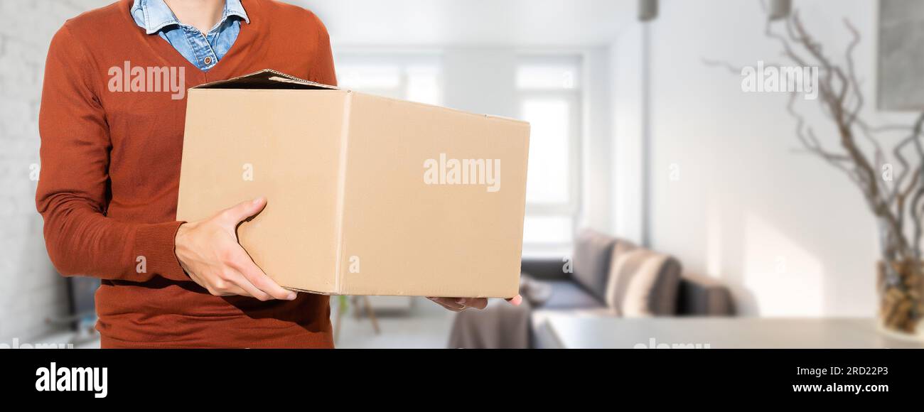 Man lifting cardboard boxes in apartment interior Stock Photo - Alamy