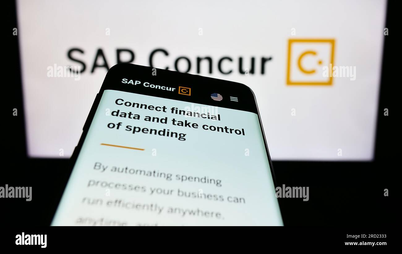 Smartphone with webpage of expense management software SAP Concur on screen in front of business logo. Focus on top-left of phone display. Stock Photo