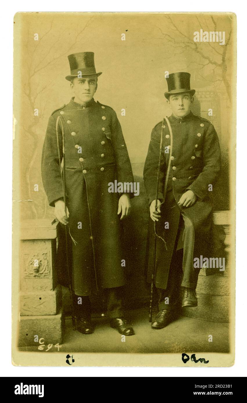 Original early 1900's  studio portrait postcard of 2 Welsh coachmen in uniform, holding horse whips, from studio of Sargent, 249 Holton Rd, Barry, Vale of Glamorgan, Wales circa early 1920's. Stock Photo