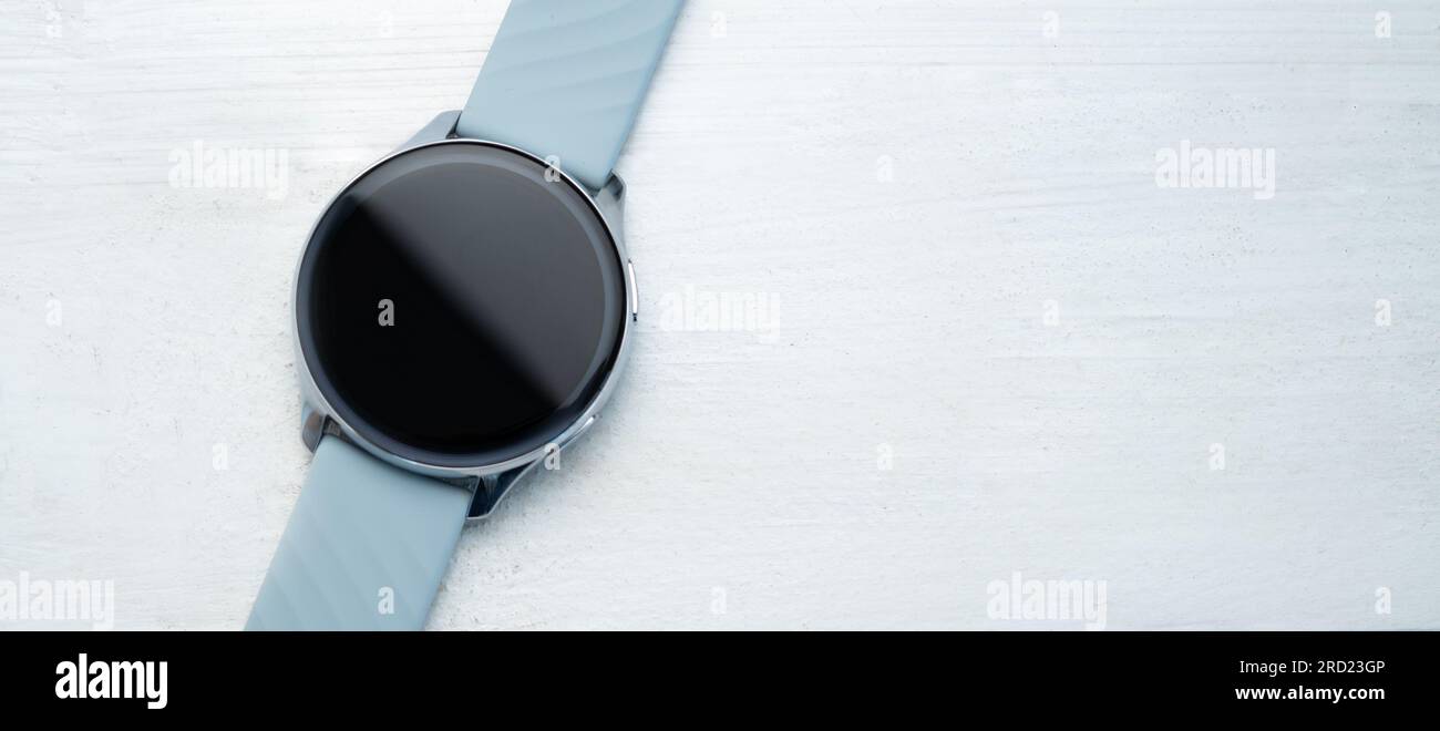 Smart watch with digital screen and copy space lying on white table ...