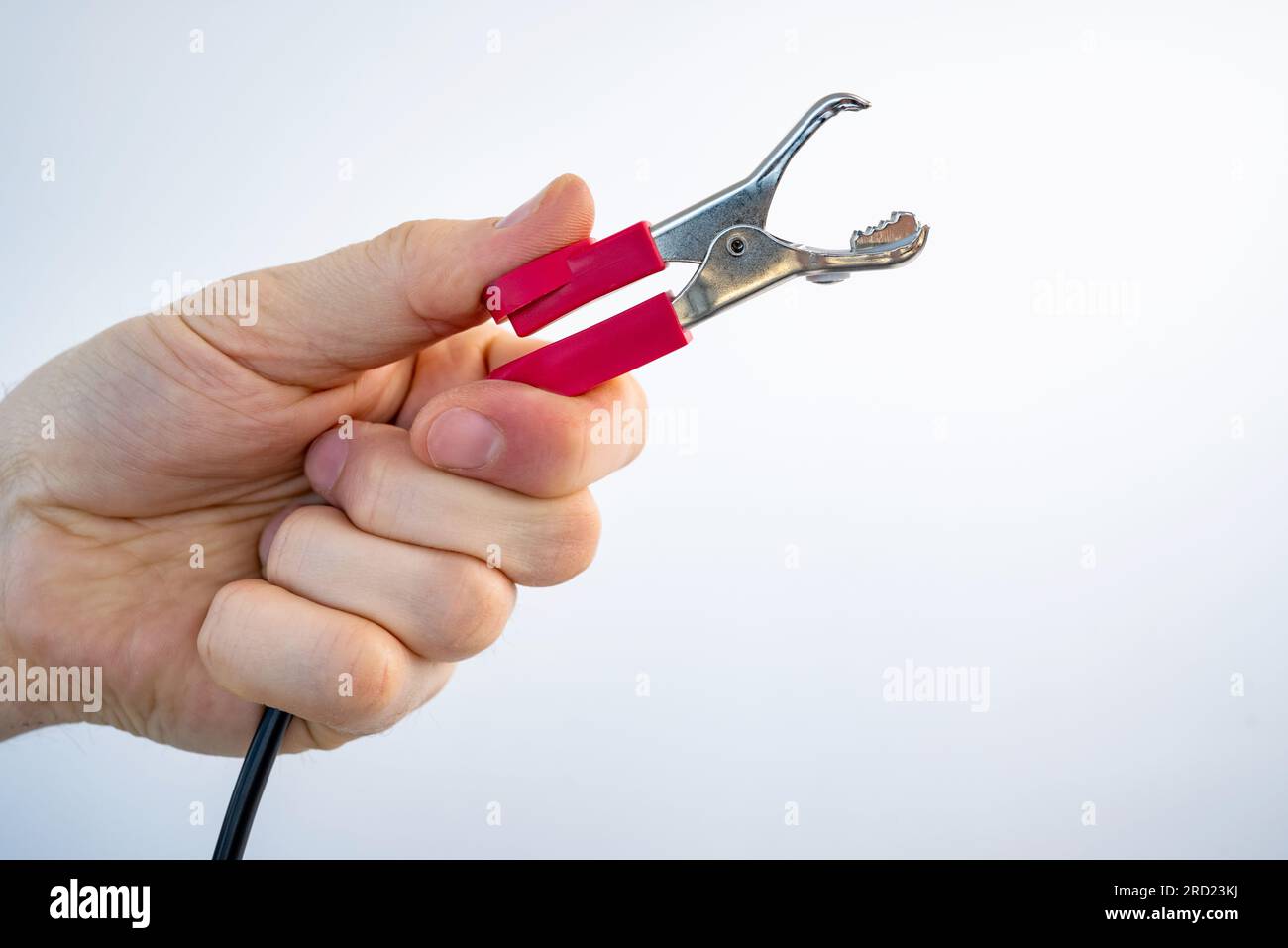 Crocodile alligator clip in guy hand for electrical and electronic