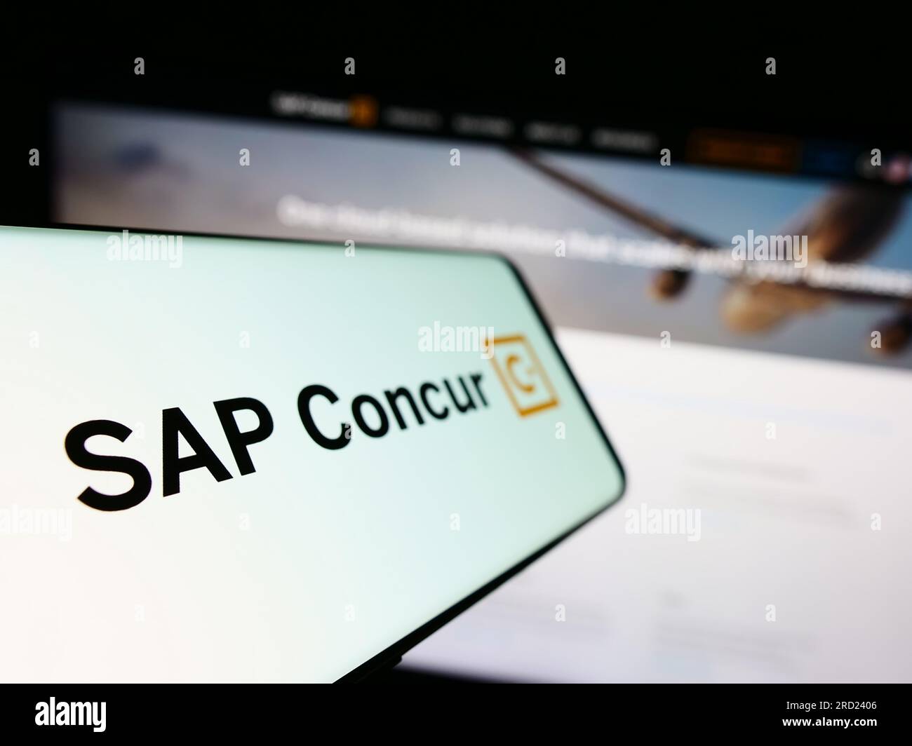 Mobile phone with logo of expense management software SAP Concur on screen in front of business website. Focus on left of phone display. Stock Photo