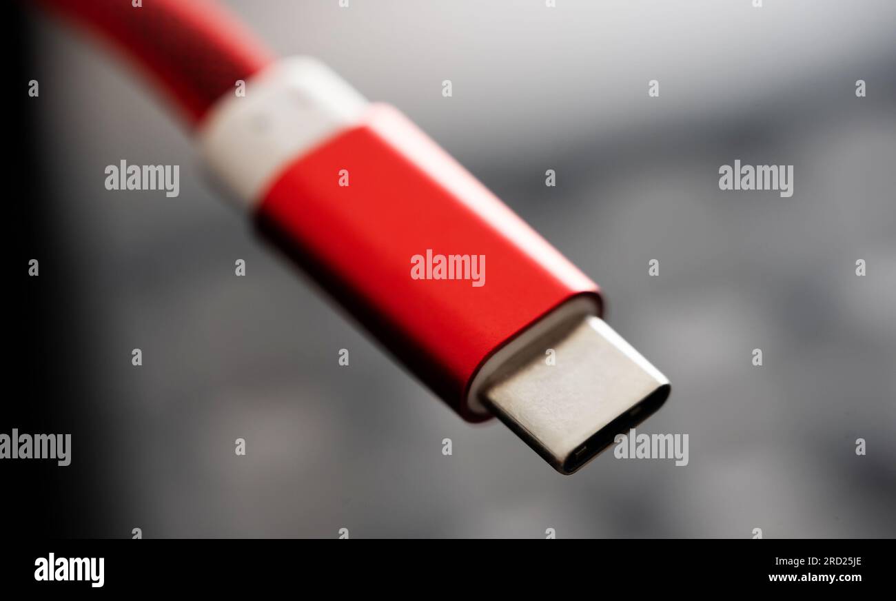 Red connector usb type C for smartphone and gadgets closeup. Plug micro cable for mobile devices in macro view Stock Photo