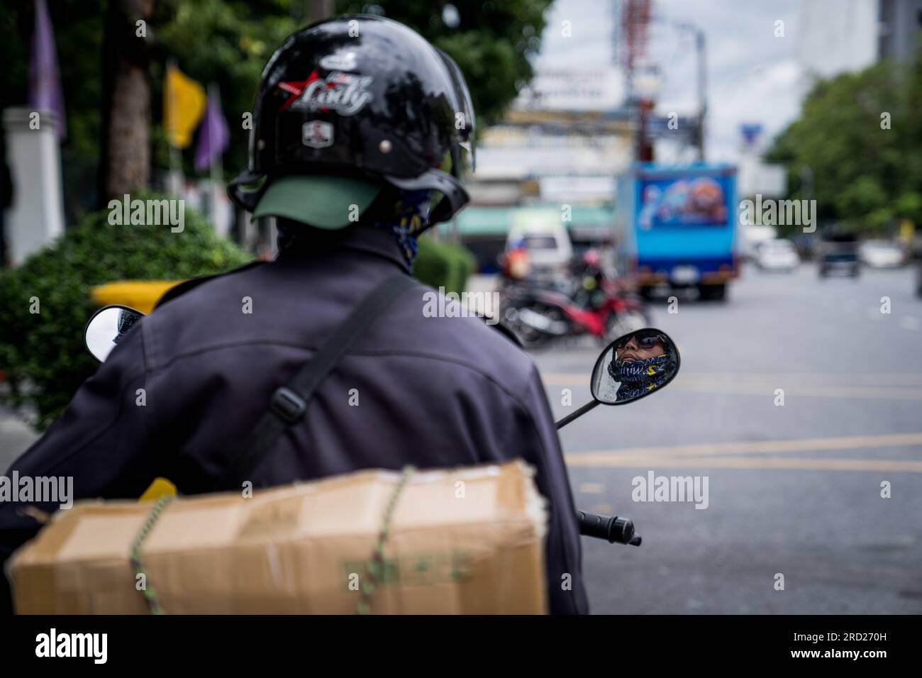 Bangkok, Thailand. 18th July, 2023. A motorcycle drivers observes ...