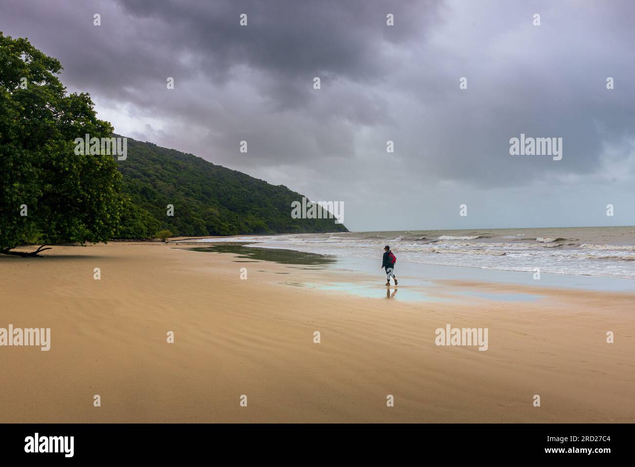 Woman strolling along an idyllic tropical beach. Stock Photo