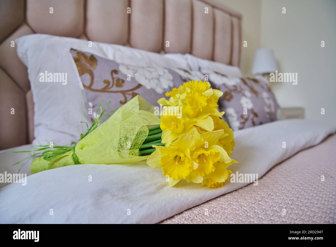 Bouquet of yellow flowers on bed in bedroom Stock Photo Alamy