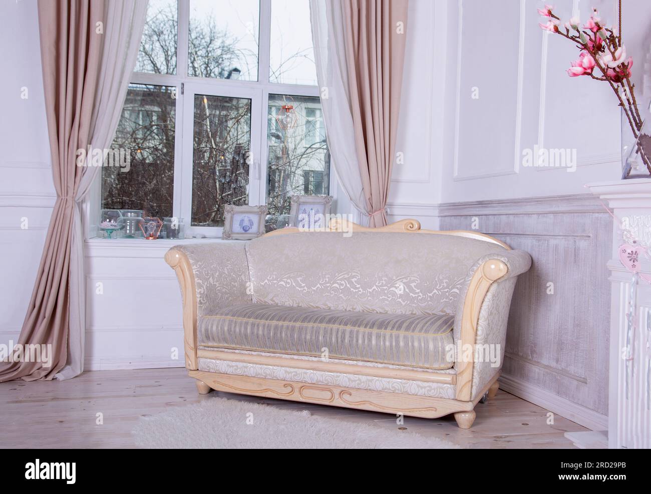 An old sofa with wooden planks by the window. Empire style furniture