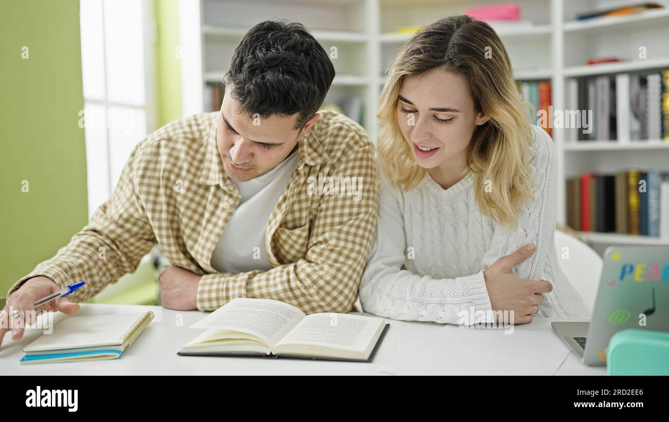 Man and woman students studying together at library university Stock ...