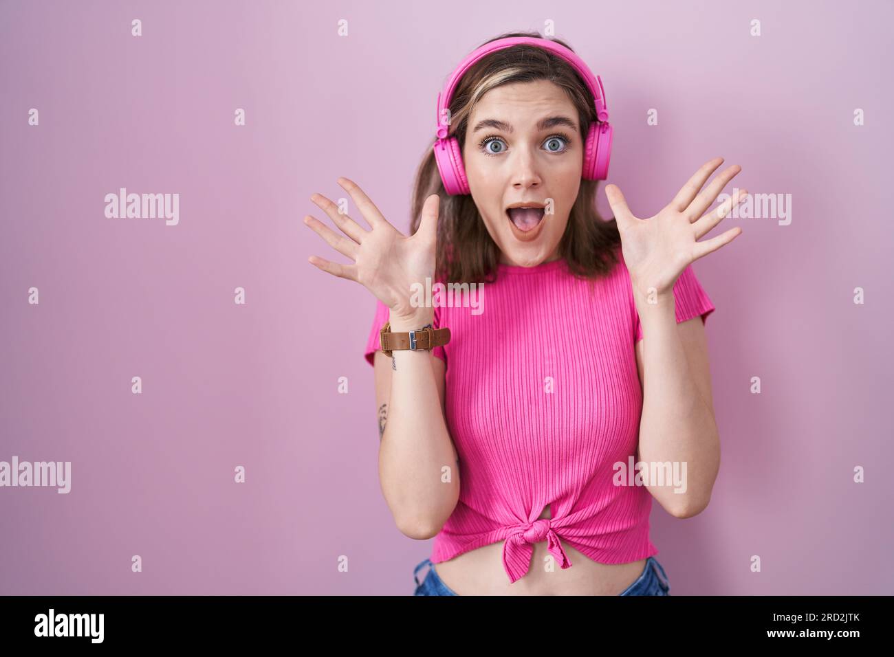 Blonde caucasian woman listening to music using headphones celebrating ...