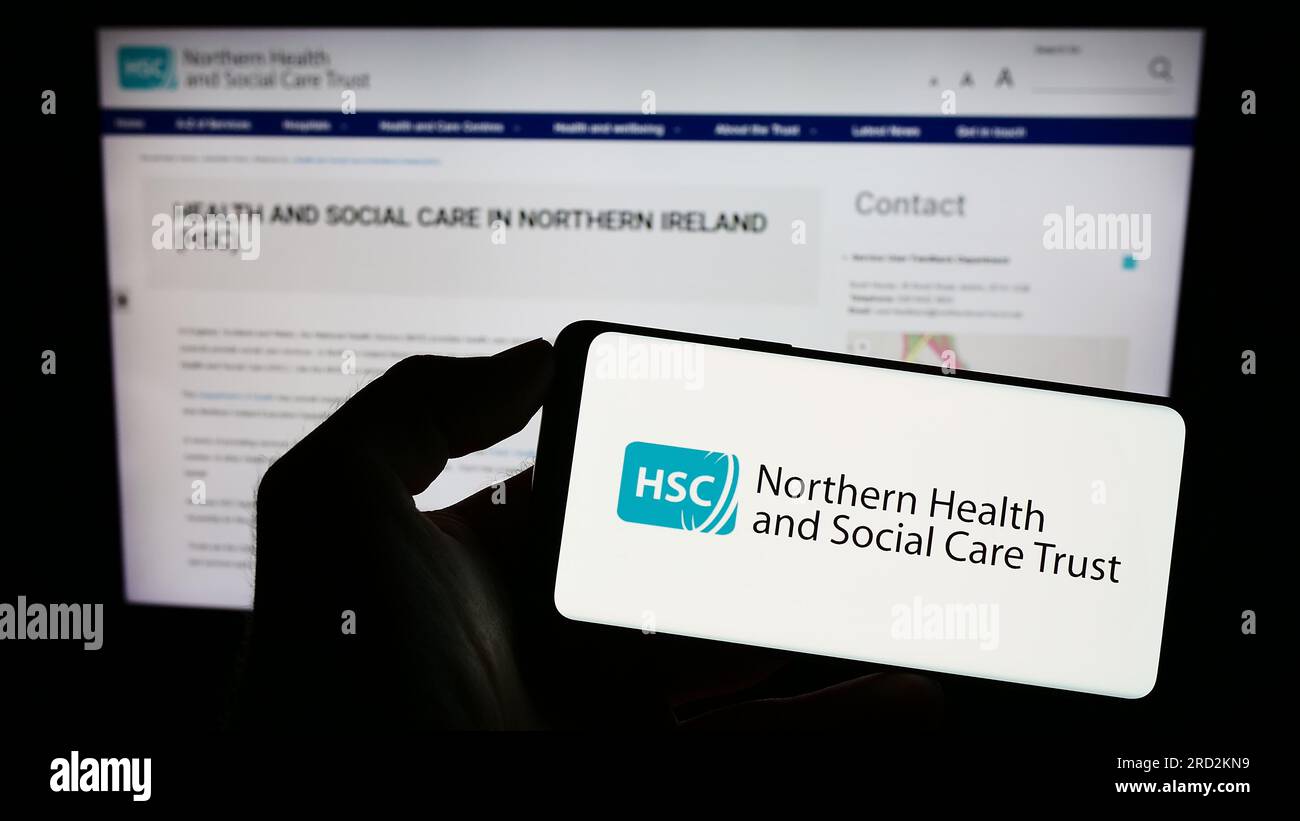 Person holding mobile phone with logo of Health and Social Care (HSC