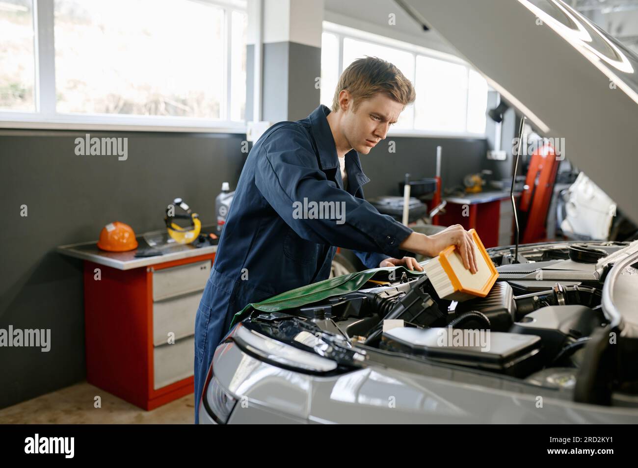 Engine air filter replacement concept, auto mechanic at work Stock Photo