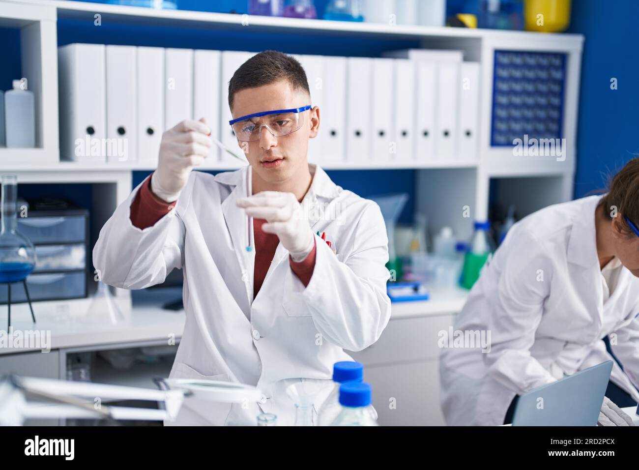 Man and woman scientists measuring liquid at laboratory Stock Photo - Alamy
