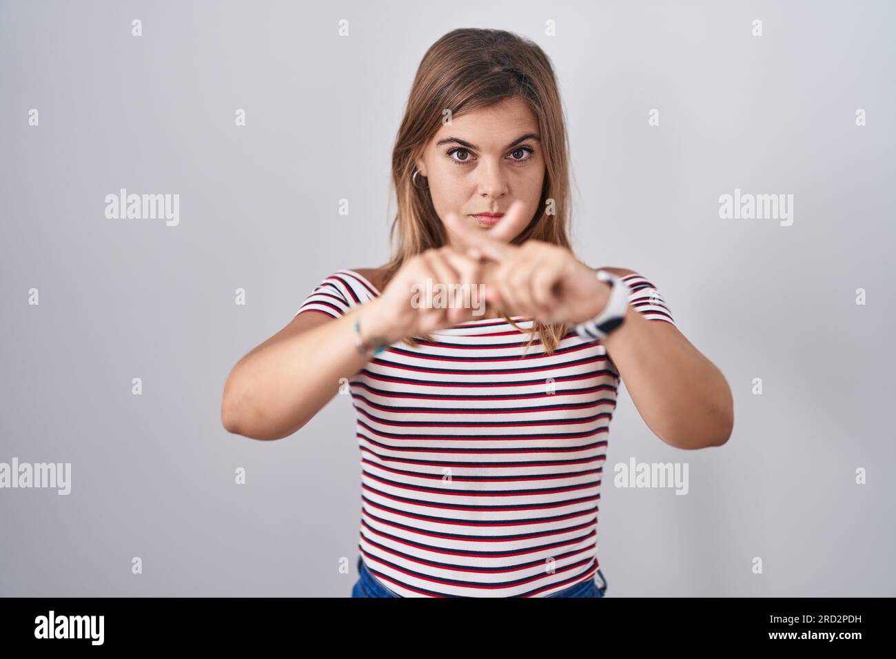 Young hispanic woman standing over isolated background rejection ...