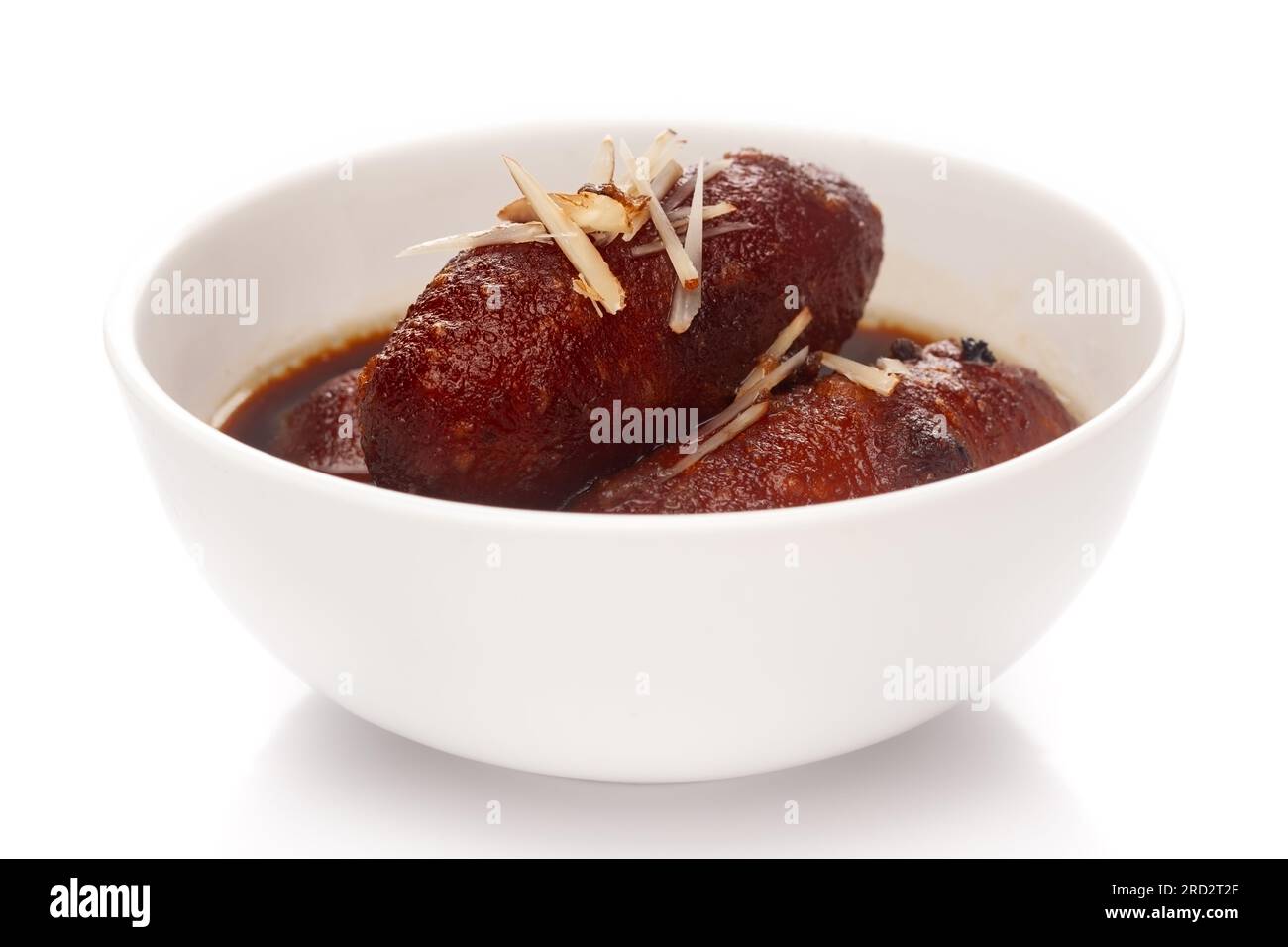 Close-up of Indian Bangali traditional sweet dish Pitha or Peetha ( Roshopuli ) made from red sweet potato, garnished with chopped almond and dry nuts Stock Photo