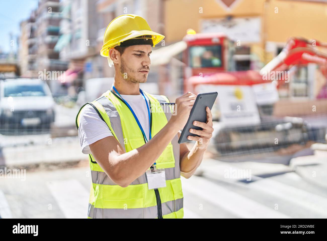 Young hispanic man architect drawing on touchpad at park Stock Photo