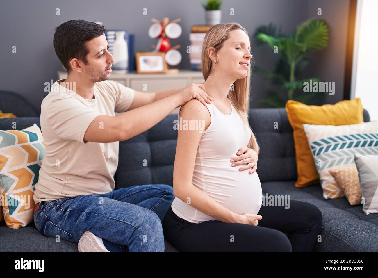 Man Expecting Man and woman couple expecting baby massaging back at home Stock Photo ...