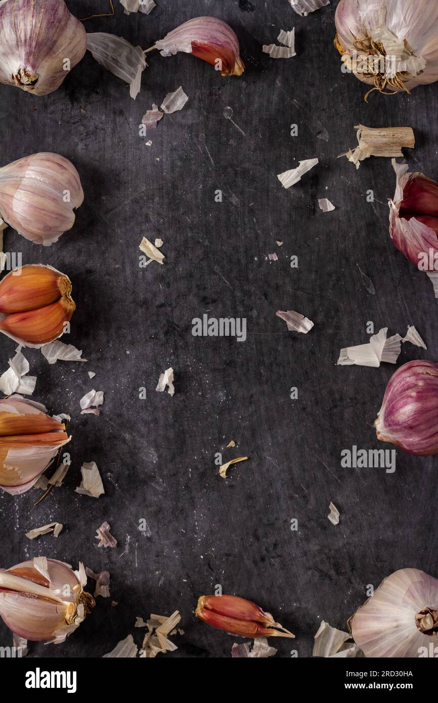 Fresh garlic bulbs and cloves grouped on black background. Flat lay ...
