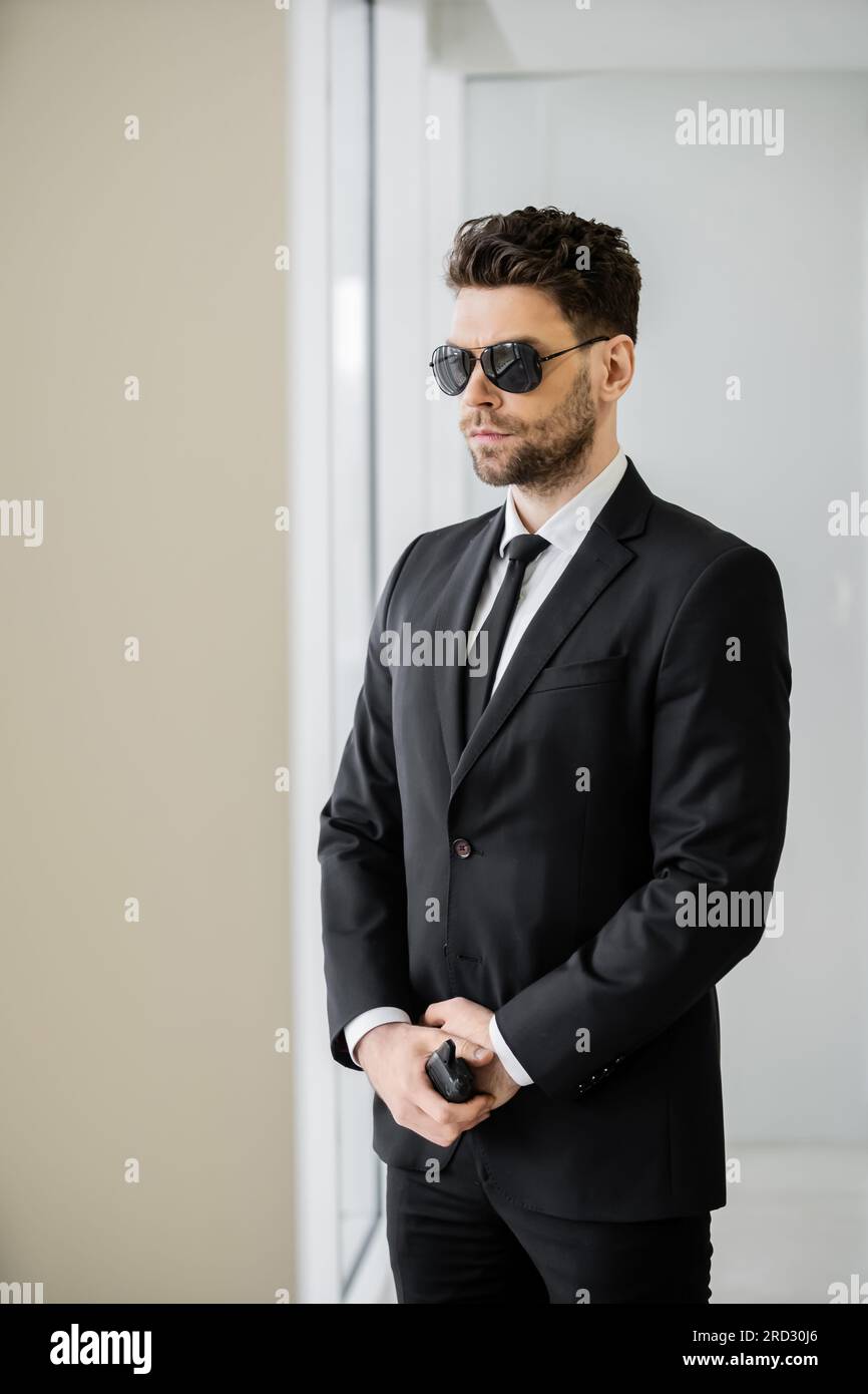 surveillance, bodyguard standing with walkie talkie, man in sunglasses and  black suit with tie, hotel safety, security management, uniformed guard on  Stock Photo - Alamy