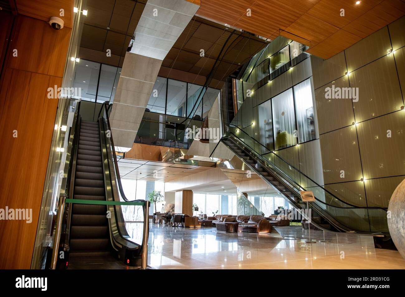 modern hotel interior with sophisticated lobby design, escalators, moving staircase, classy leather couches, lavish ambience, spacious and comfort, el Stock Photo
