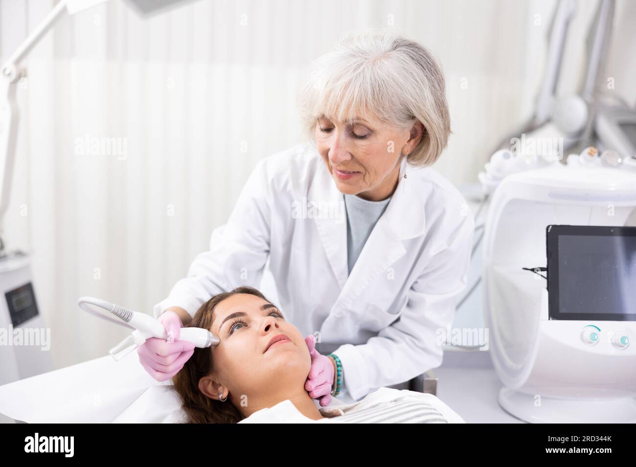 Young woman at appointment with beautician doing ultrasound face