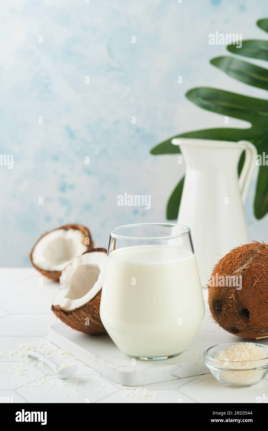 Glass of coconut milk and coconut close up on a white background with space for text. Coconut vegan milk non dairy or Dairy free milk concept. Healthy Stock Photo