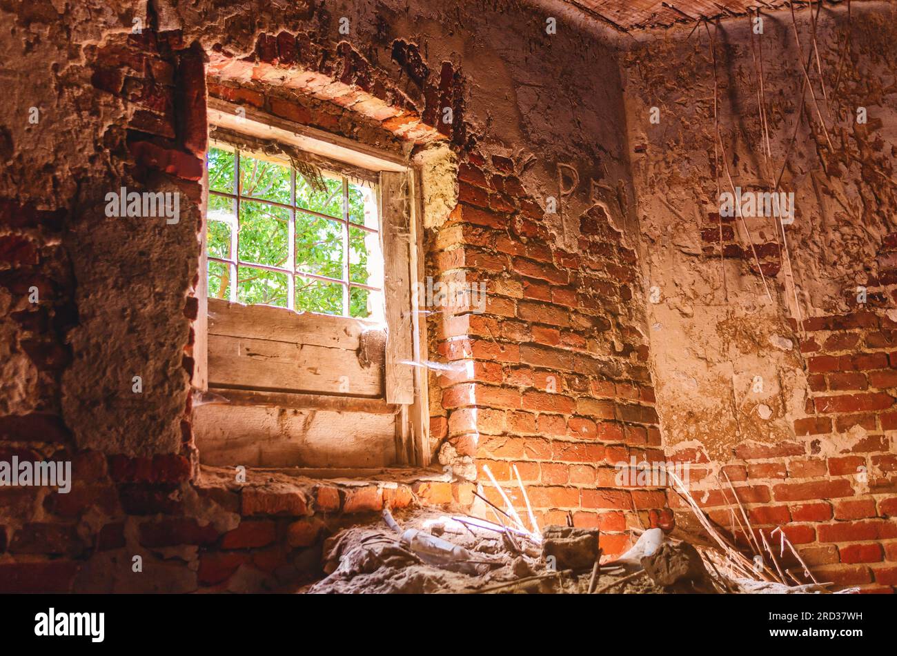 Old broken window in an abandoned bid. The sun glows inside an abandoned church Stock Photo