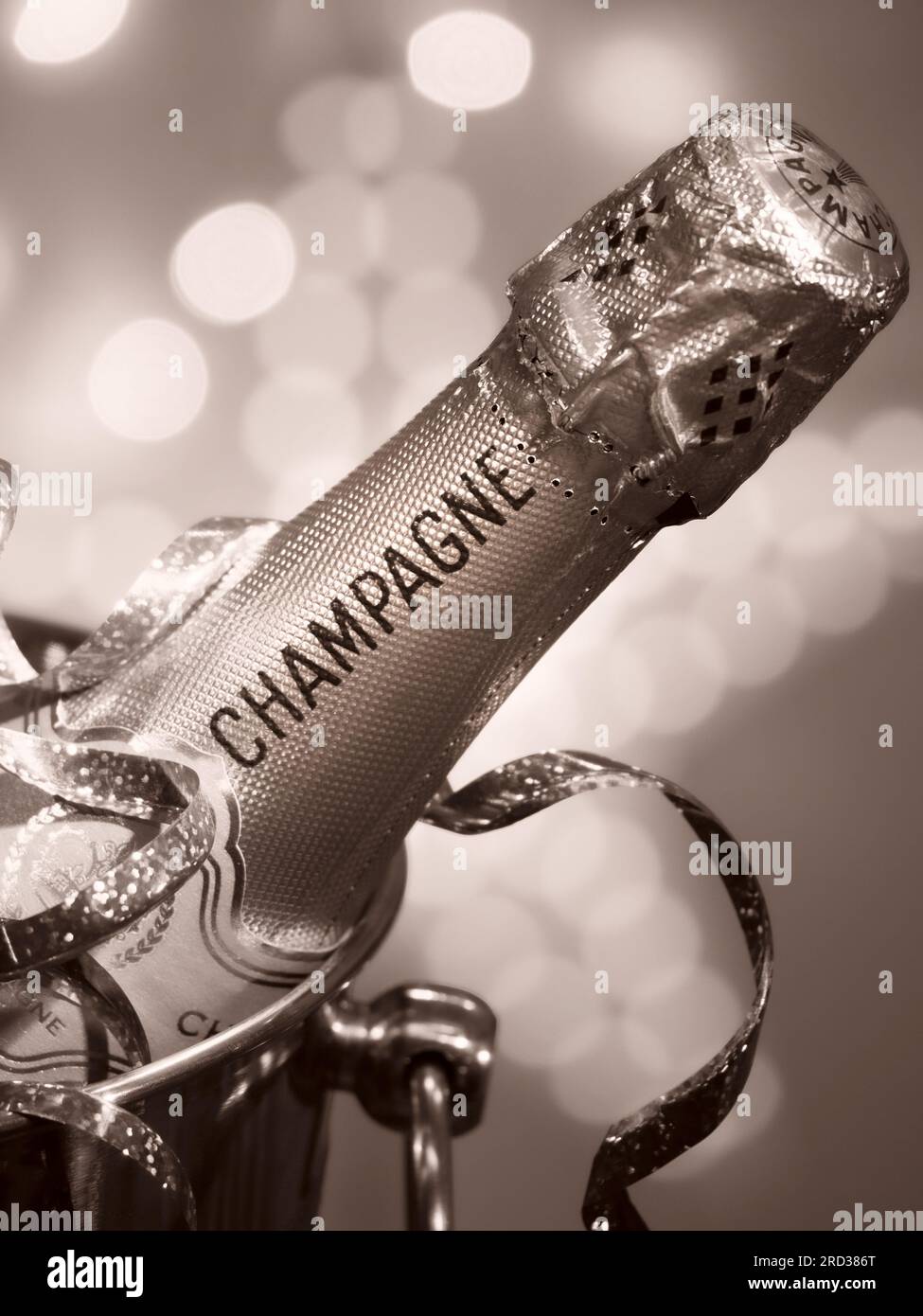 CHAMPAGNE BOTTLE RETRO VINTAGE B&W PARTY LIGHTS  on ice in wine cooler champagne ice bucket, party streamer and sparkling style celebration lights Stock Photo