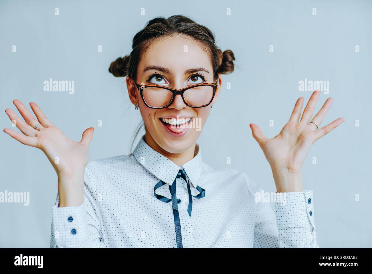 Young business woman funny portrait with glasses on white wall background Stock Photo