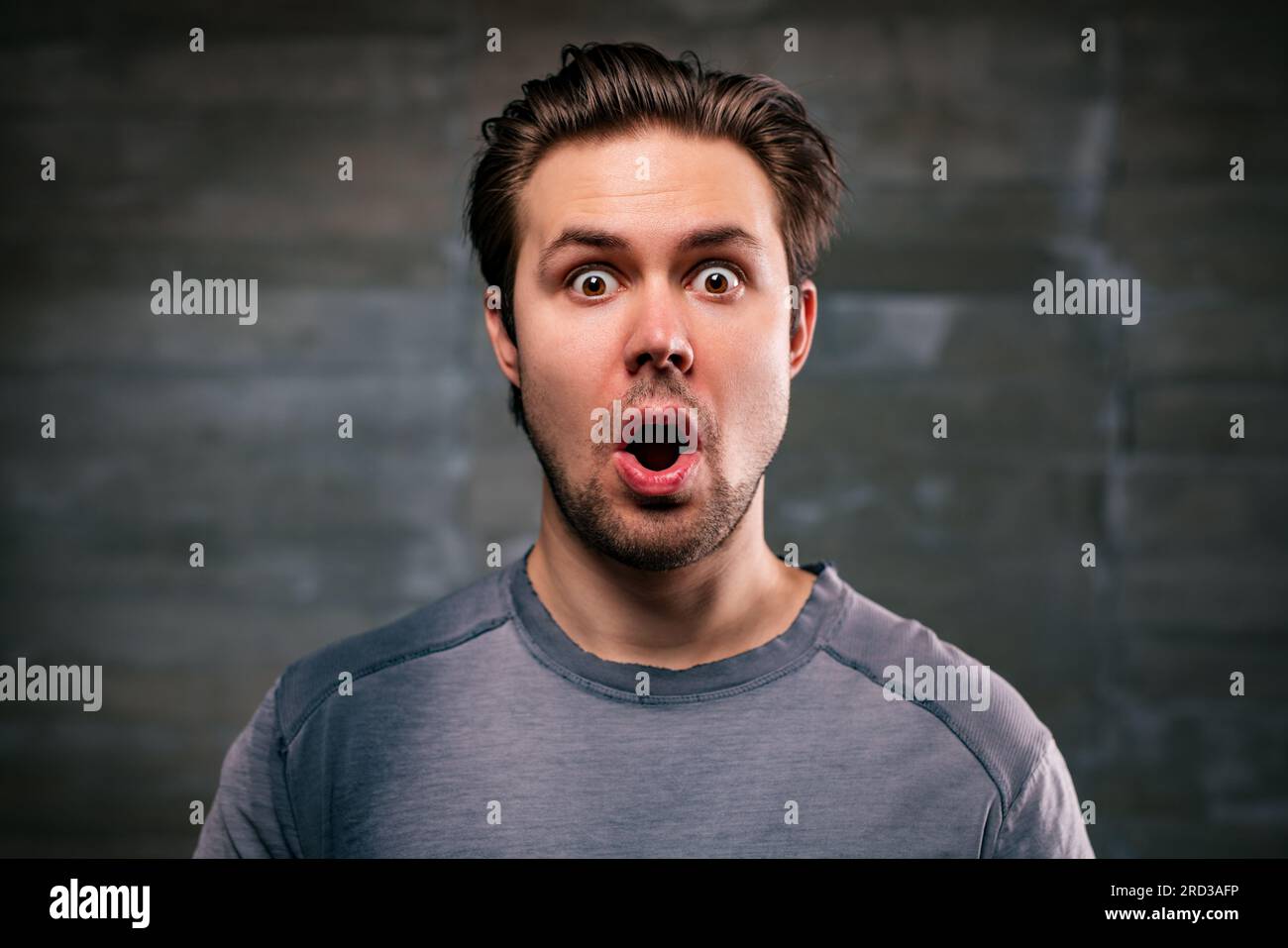 Young handsome man wow emotional portrait on gray wall background Stock Photo
