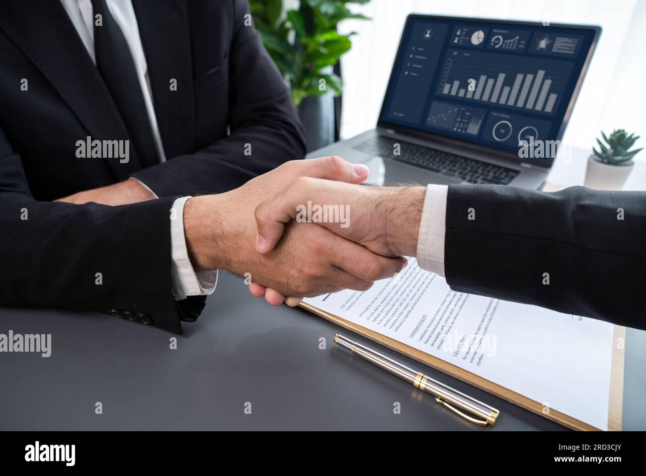 Two professionals successfully close business deal with closeup