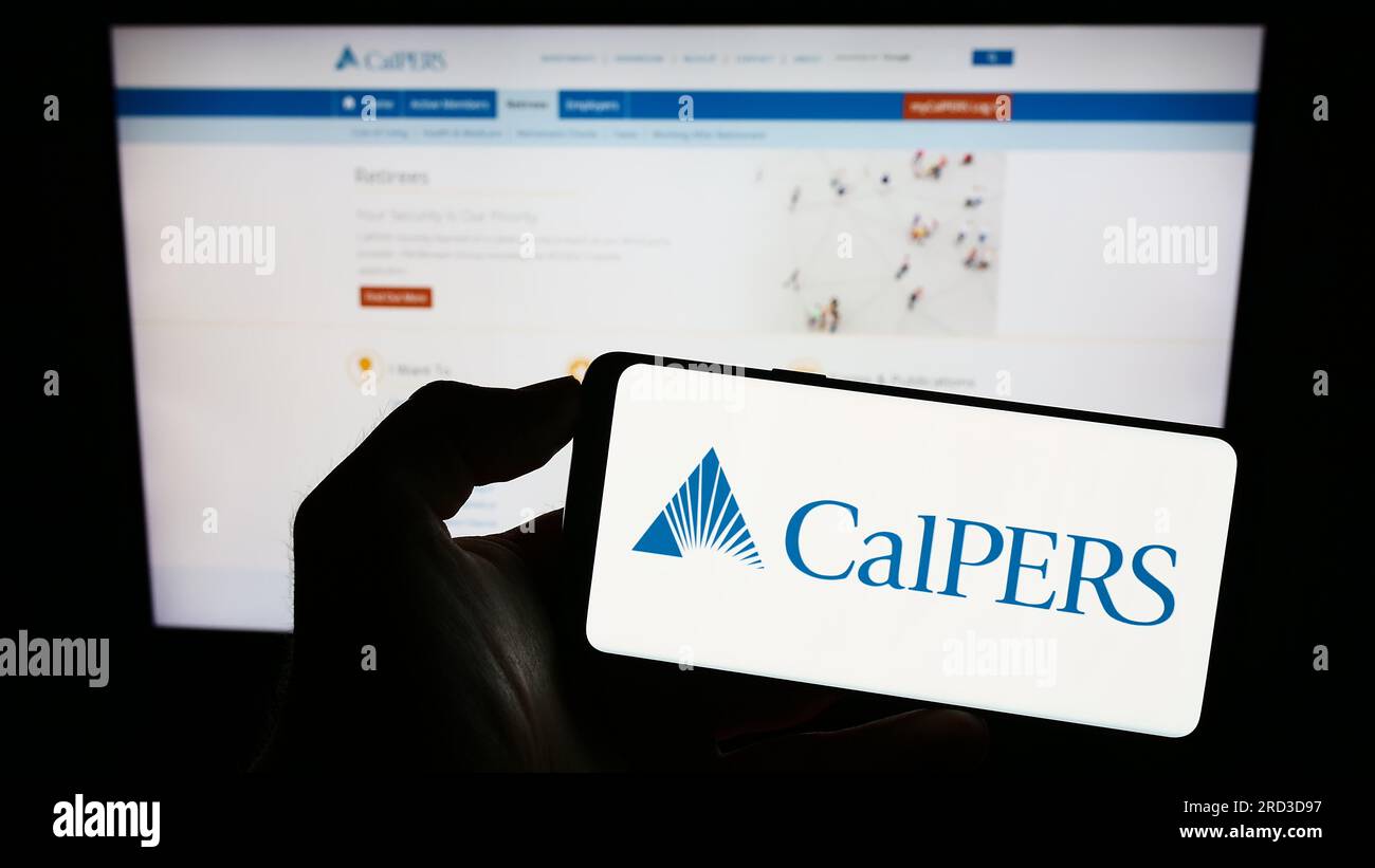 Person holding cellphone with logo of Californian retirement system CalPERS on screen in front of webpage. Focus on phone display. Stock Photo