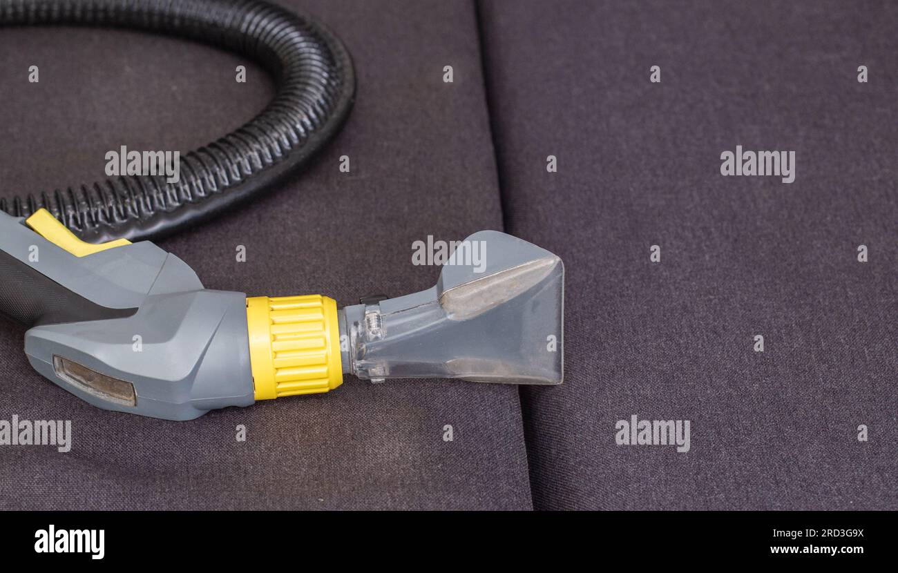 Washing vacuum cleaner with a special nozzle on the black upholstery of