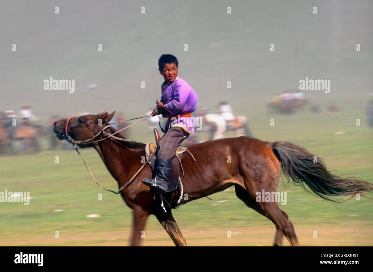 Asia Mongolia Naadam Festival or Eriin gurvan naadam nomadic boy on horse in the steppe Stock