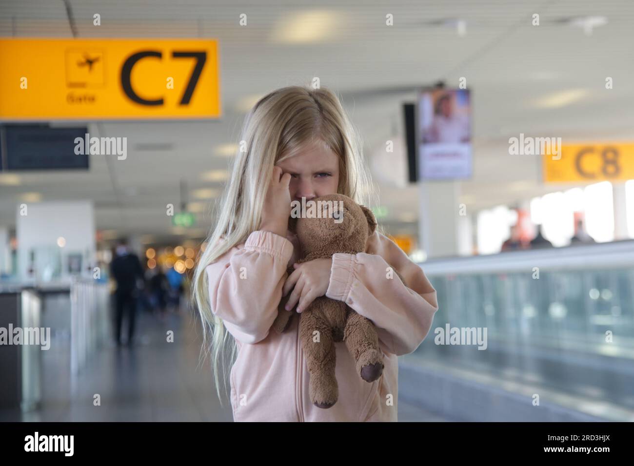 Child lost at the airport, can't find her parents. Upset little girl