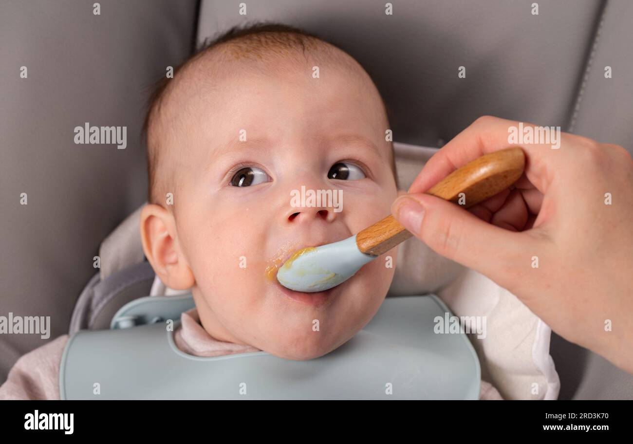 A little boy caucasian has been trying porridge and fruit puree for 6