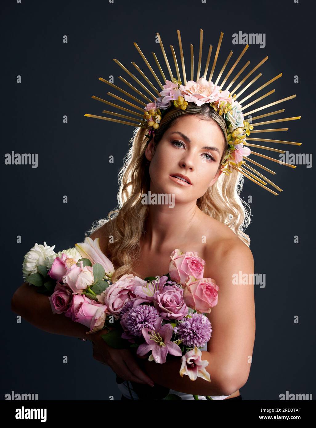 Woman, flowers and crown in studio portrait for goddess, beauty or wellness for new beginning by black background. Girl, model and bouquet with plants Stock Photo