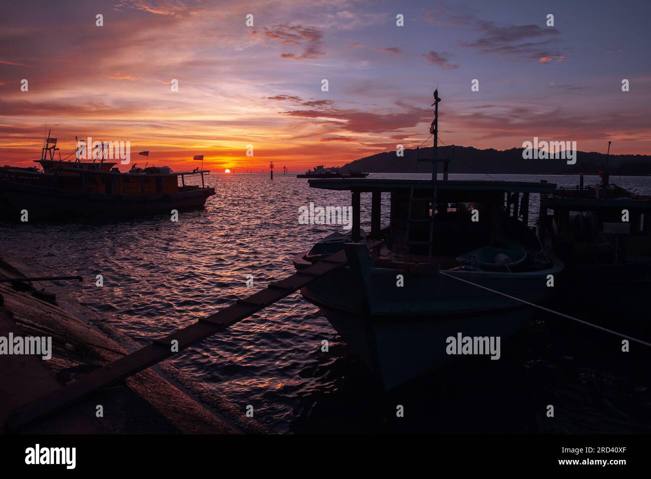 Fishing boats with Malaysian flags moored at KK Fish Market on a sunset Stock Photo