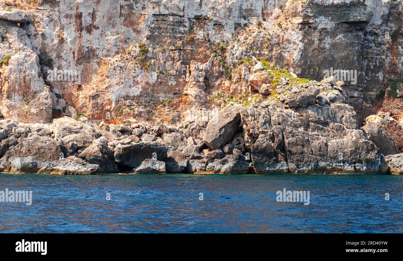 Sea water and rocky coast of Comino island on a sunny day, Malta Stock Photo