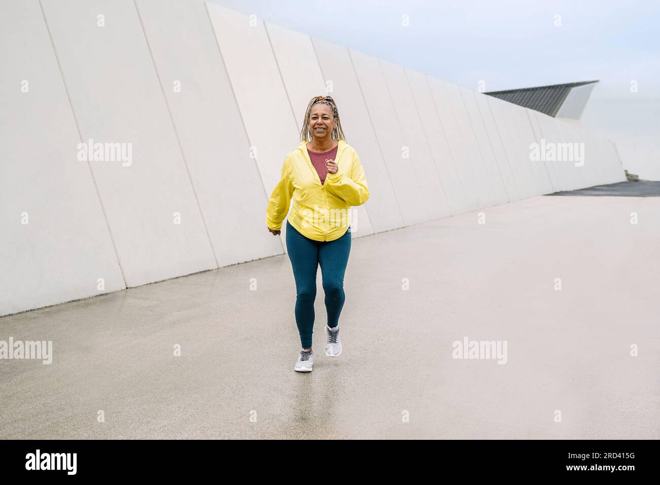 Sport senior African woman training while running at urban park - Elderly healthy lifestyle concept Stock Photo