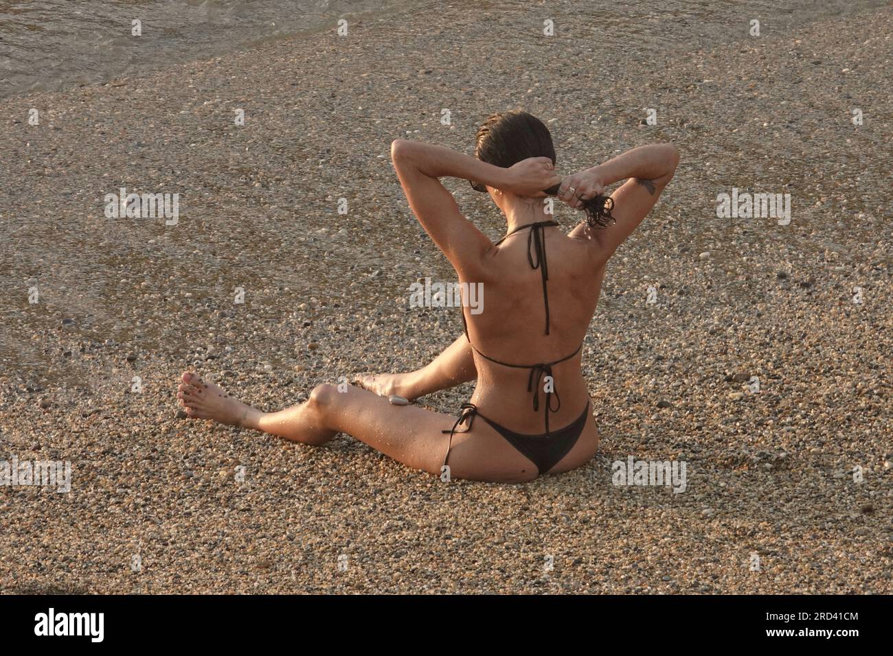 Biarritz, France, July, 2023  Lady tidies up her hair after a swim on the Plage du Port Vieux, in Biarritz Stock Photo